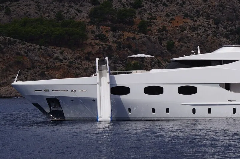 Custom superyacht slide in use — charter guests enjoying inflatable water slide at anchor